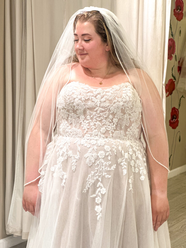 woman wearing off the rack plus size wedding dress in los angeles california bridal shop