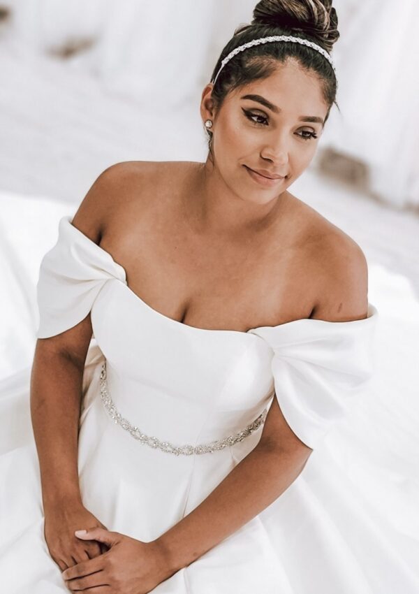 bride sitting in classic satin wedding dress with sleeves